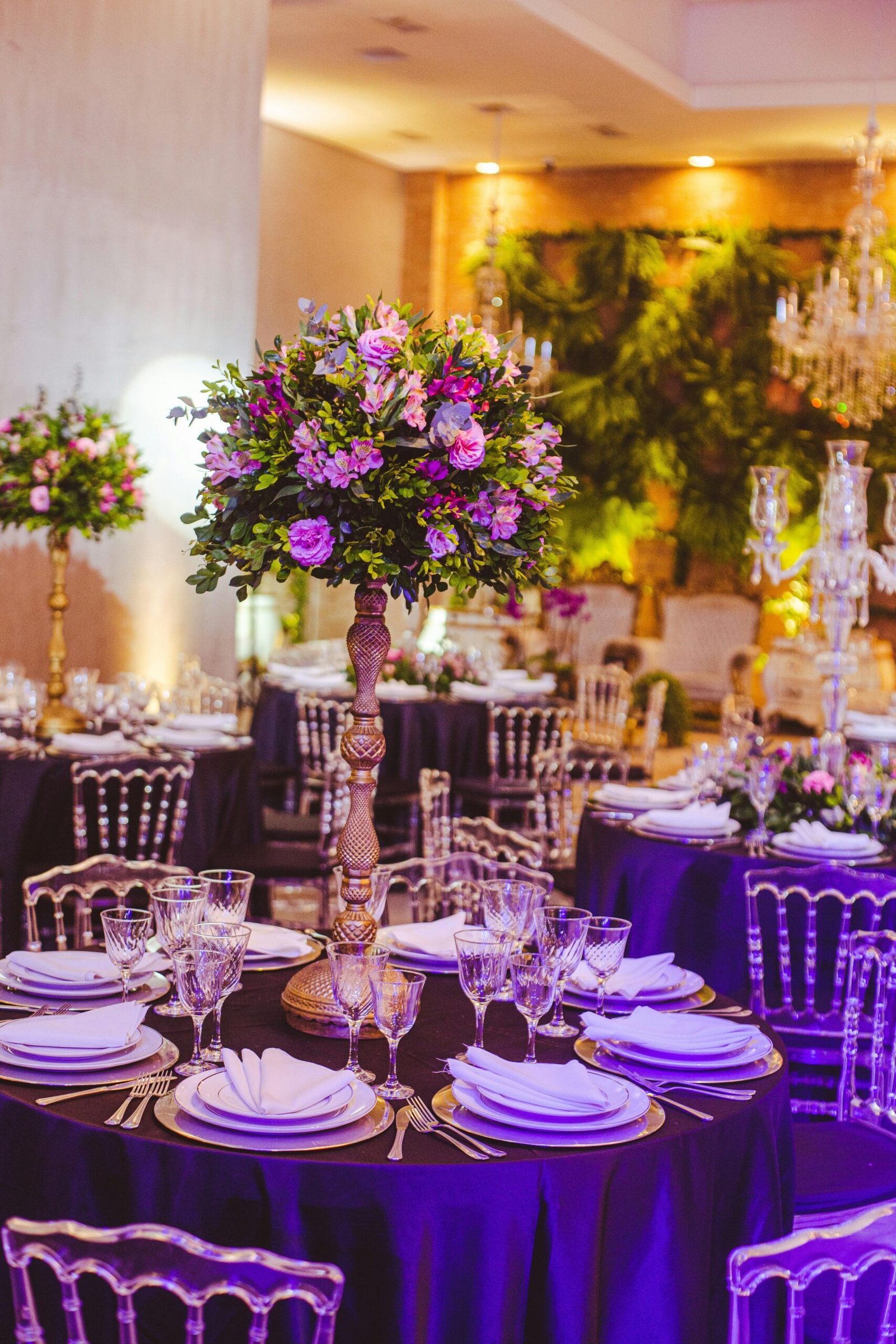 Luxurious wedding reception with floral centerpieces, elegant table settings in a beautifully decorated venue.